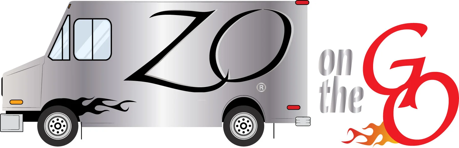 Zo Greek’s Zo on the Go food truck wrap: a brushed-silver step van with a large black Zo script logo and flames, beside the words on the Go with a red G trailing flames