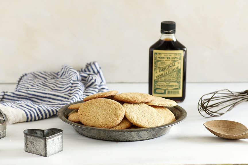 A bottle of Dolan vanilla beside a plate of sugar cookies